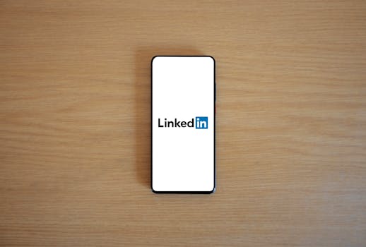 Top view of a smartphone displaying the LinkedIn logo on a wooden surface.