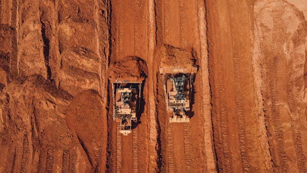 Aerial shot of two tractors excavating red earth, showcasing construction and mining machinery in Brazil.
