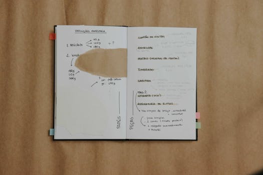 An open notebook displaying handwritten notes and diagrams on paper specifications and design ideas.