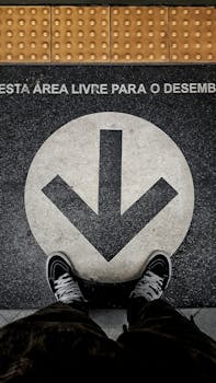 Close-up of a pavement arrow and sneakers indicating direction in a metro area.